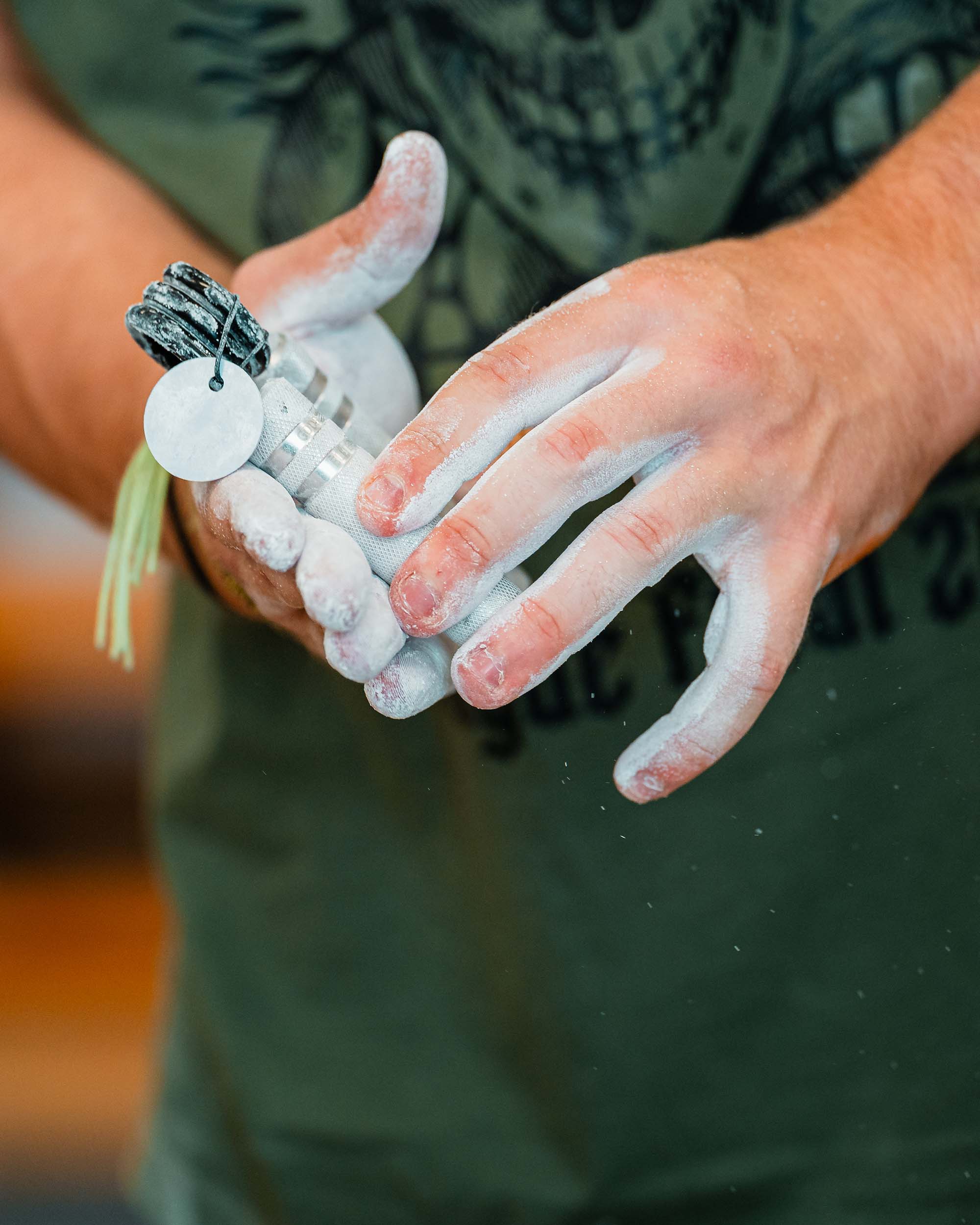 chalked hands with hand gripper
