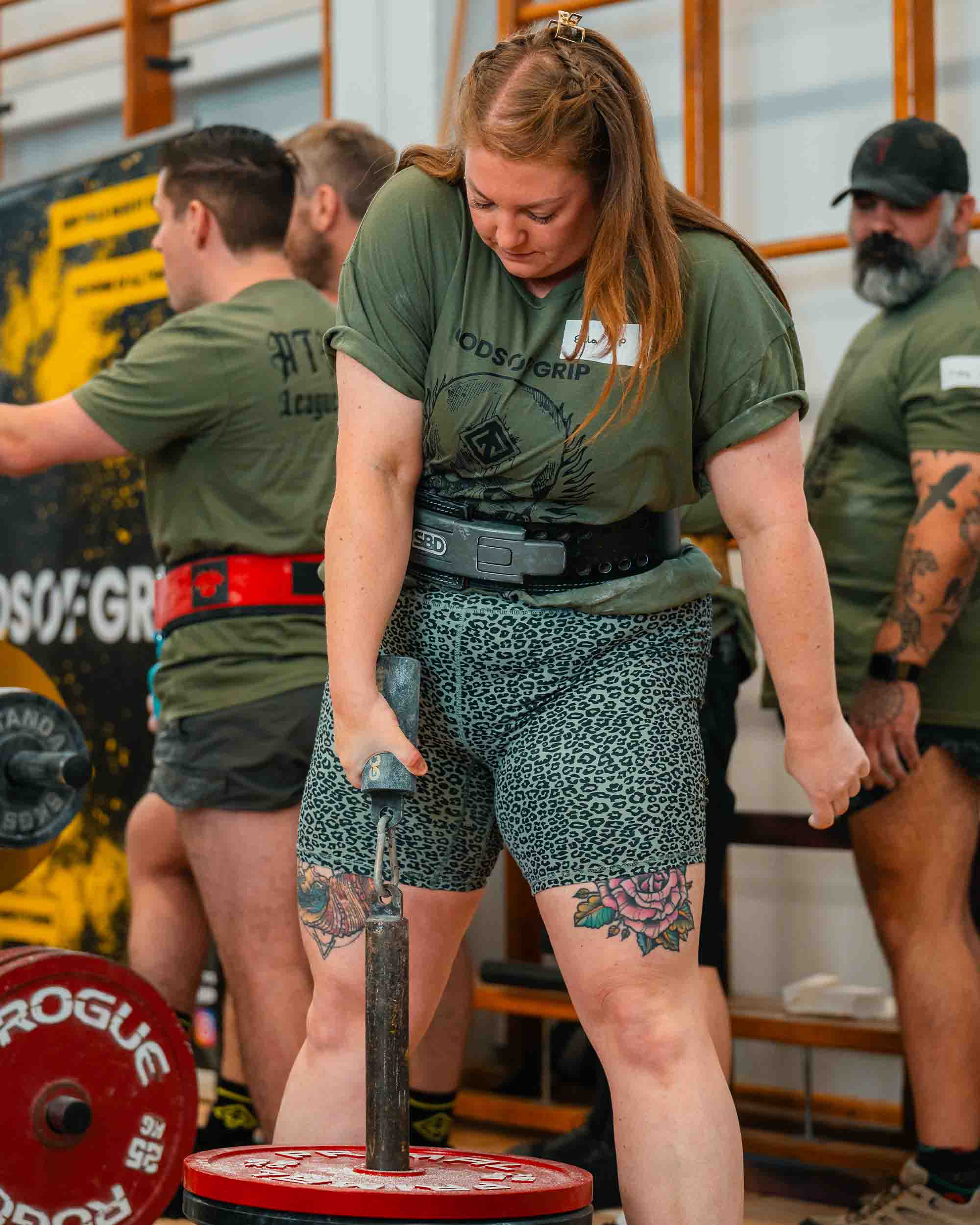 Person lifting weights with others in a gym setting